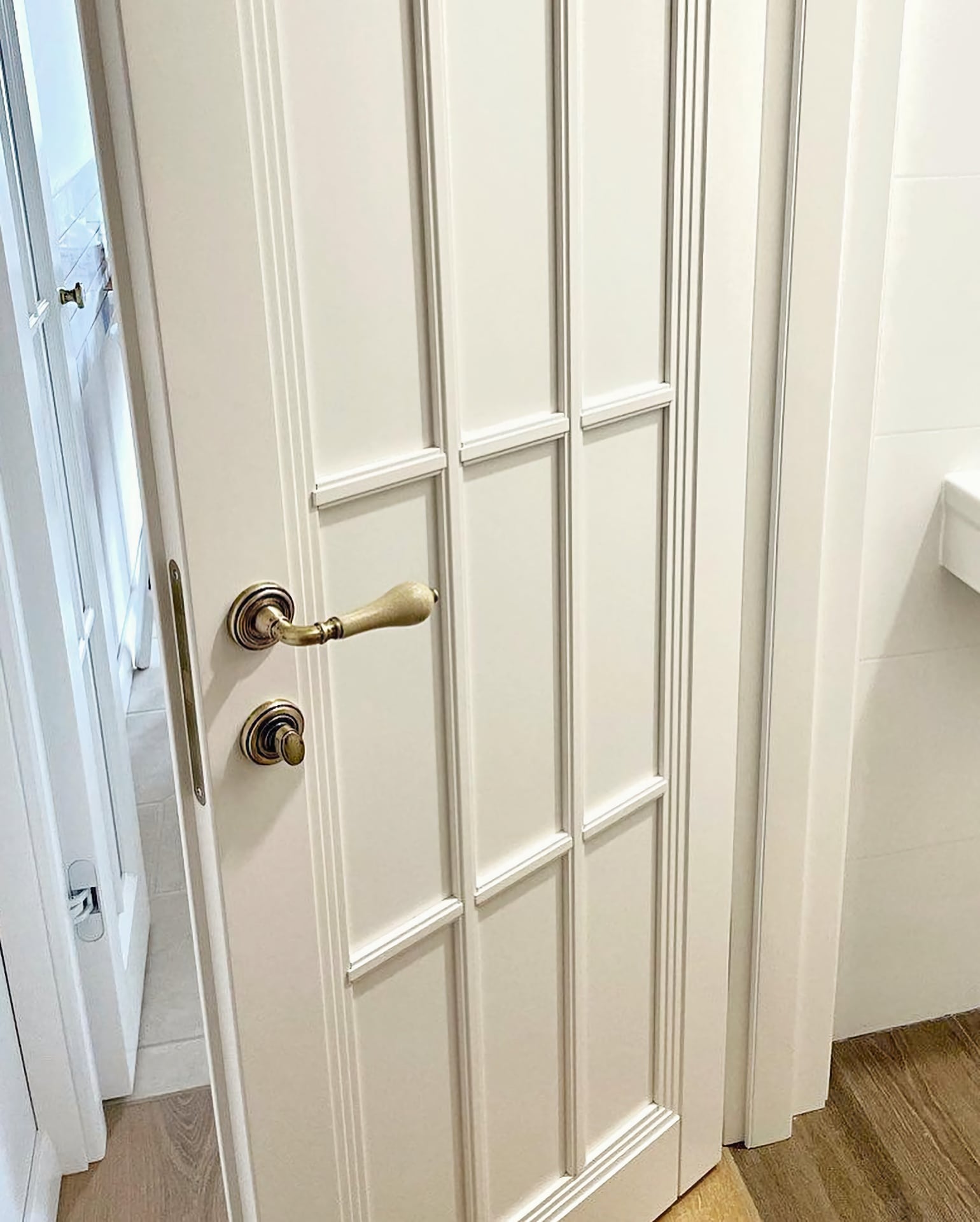 Дверь белая межкомнатная – глухое полотно, видно качественную фурнитуру с защёлкой