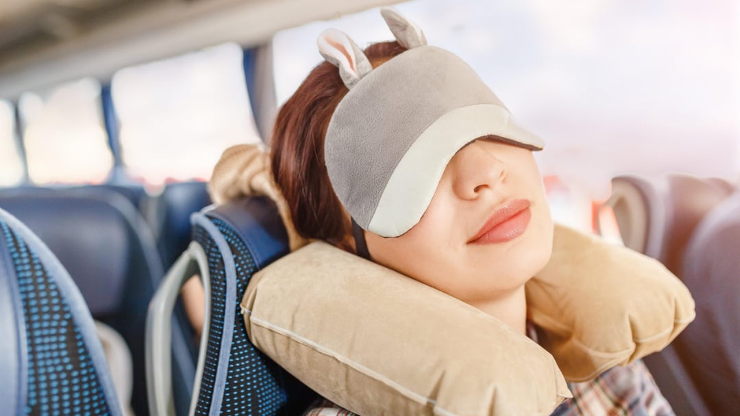 Дівчина спить в автобусі, прикривши очі маскою для сну