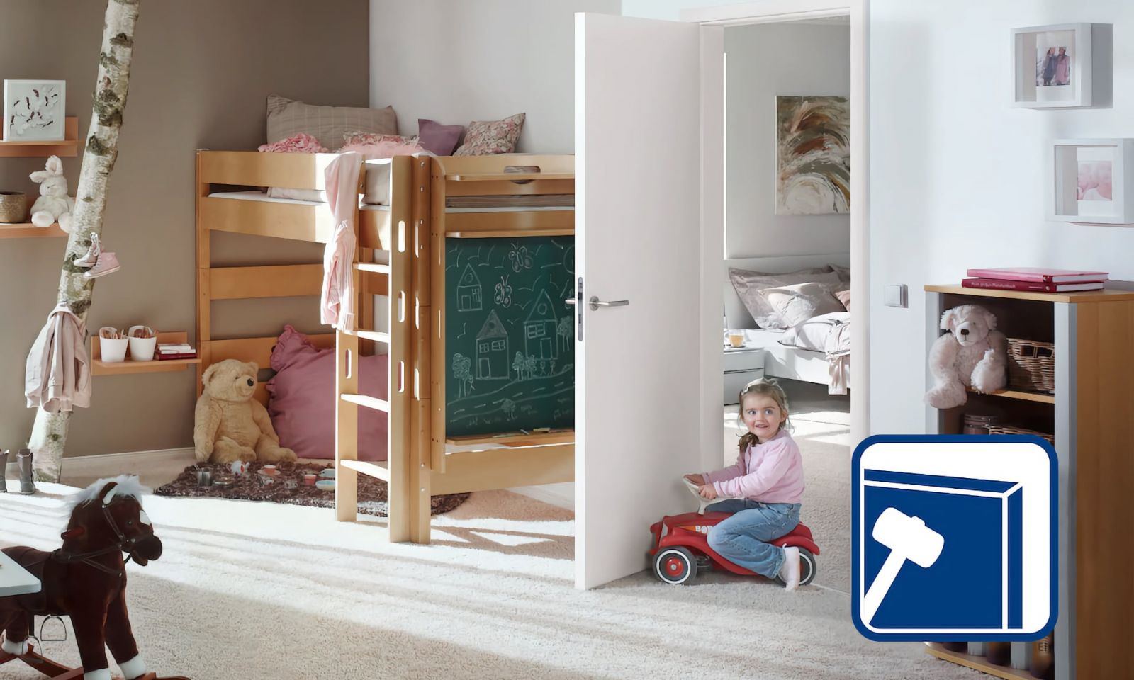 Девочка играет в детской комнате, окруженной игрушками, кроватью-горищем, белой дверью и декоративными элементами.
