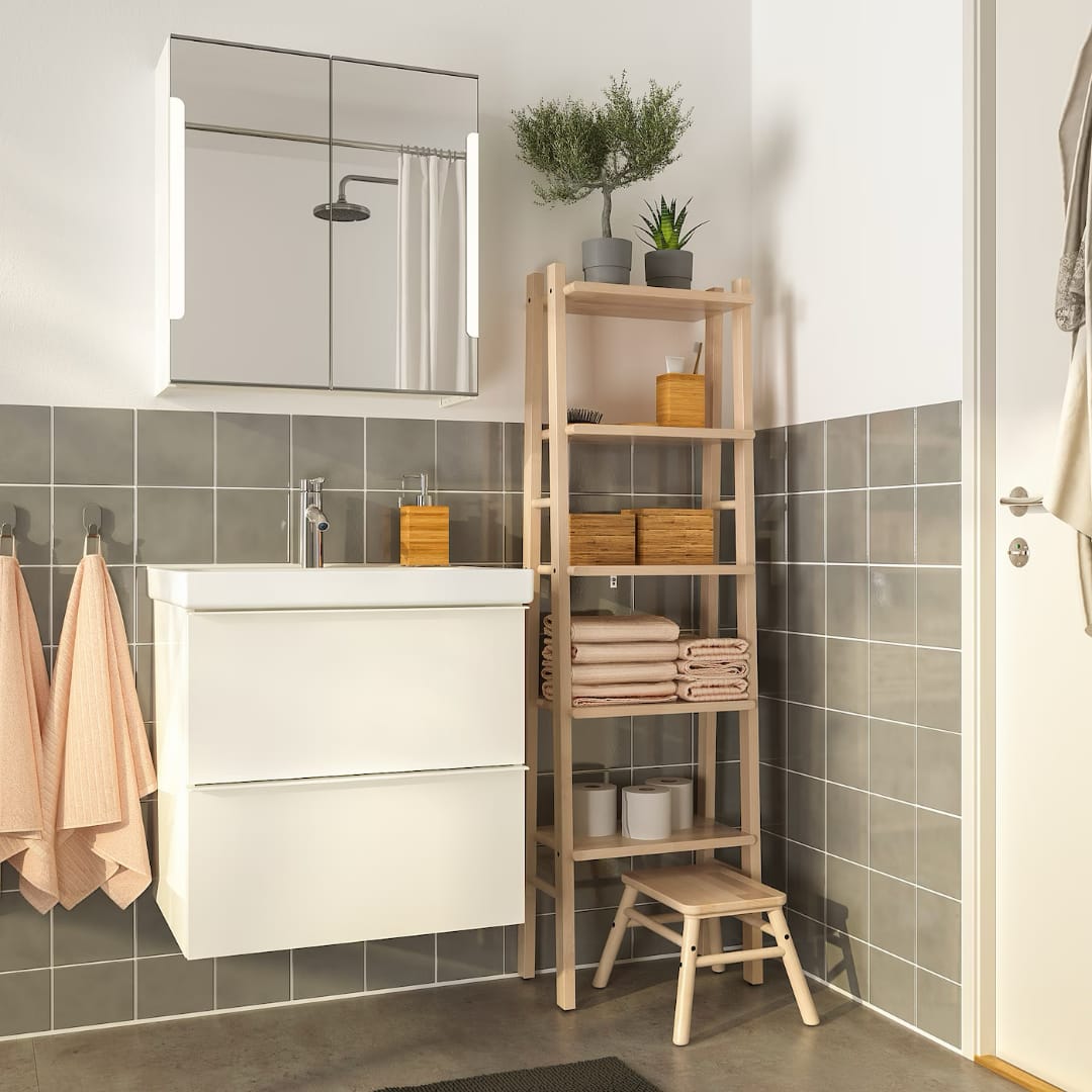 Современная ванная комната с раковиной и зеркалом, деревянный стеллаж с полотенцами и растениями, уютное и функциональное пространство.