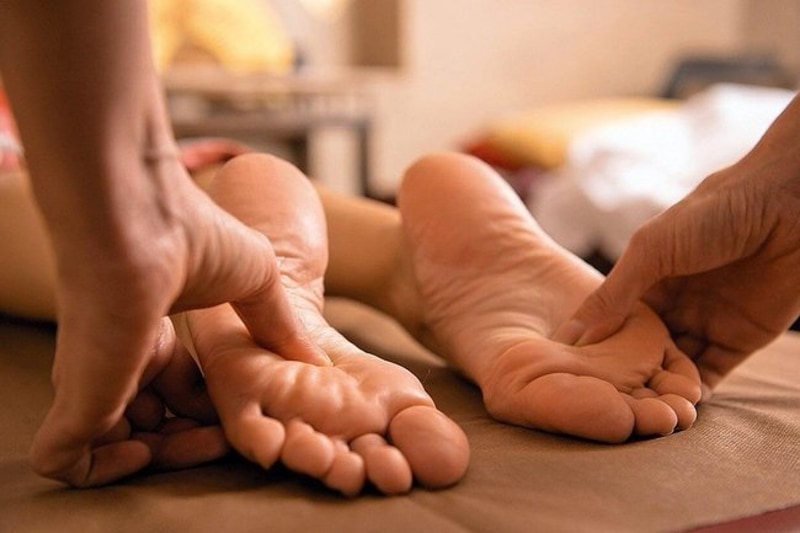 Професійний масажист робить масаж стоп клієнту. Такий масаж може включати різні техніки, спрямовані на розслаблення м'язів, покращення кровообігу та загального самопочуття. Це візуальне відображення процедури, яку можна отримати у спа-салоні, та яка може бути частиною оздоровчої програми чи ритуалу догляду за собою.