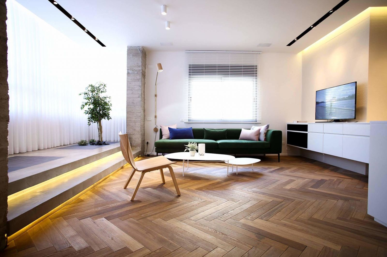 Минимальный набор мебели, и небольшой подиум визуально увеличиваетпространство гостиной