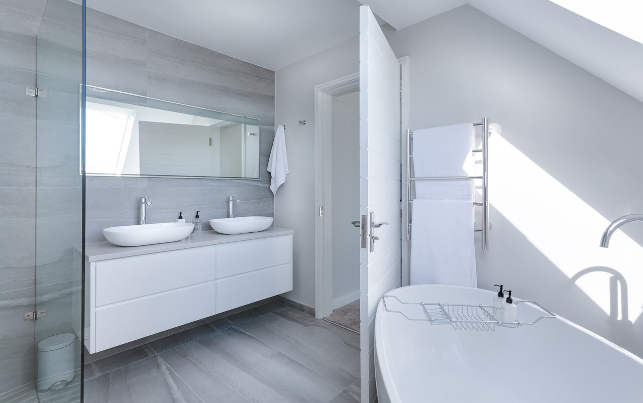 Минималистично оформленная ванная комната с душевым уголком за стеклянными стенками.